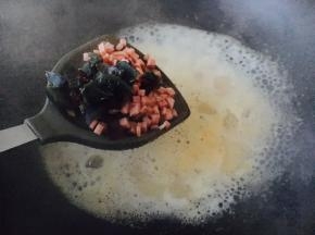 高汤煮开后放入皮蛋碎和火腿碎，再将汤煮开。