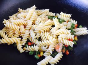 把煮好的意面放入炒好的四季豆虾仁中。