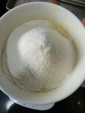 筛入低粉和泡打粉，用手动打蛋器呈“Z”字形搅拌均匀，不可以划圈搅拌，防止面粉起筋
