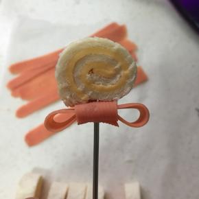 把蝴蝶结和芝士卷用叉固定好