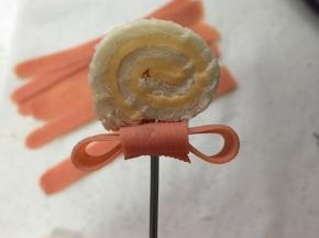 把蝴蝶结和芝士卷用叉固定好