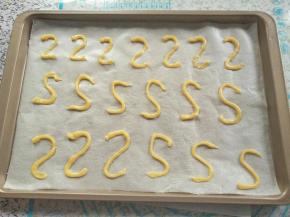 剪一个小口，在烤盘上挤出天鹅的头颈，写2字就好，如果组一对天鹅，要反方向也挤2字