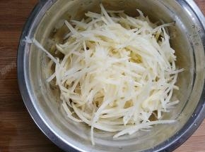 将土豆用擦丝器擦成丝状