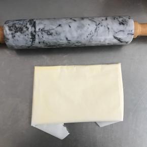 将黄油取出，切成小块状，用油纸包好，擀成长方形的薄片，大概7mm厚。