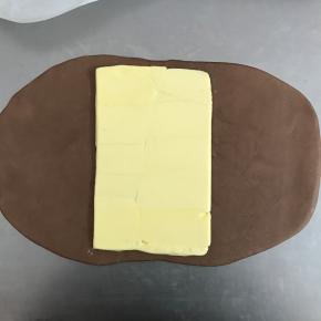 将冷冻好的面团拿出，包入黄油。