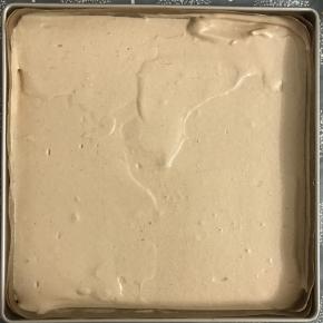 把面糊从高处倒入金盘中，刮平表面，轻震出大气泡。