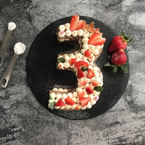 盖上另一片蛋糕片，继续挤上奶油，放上水果，鲜花等装饰就完成啦。