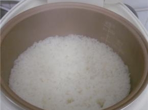 米饭煮至9成熟、倒入炒好的食材，遮上锅盖继续煲饭