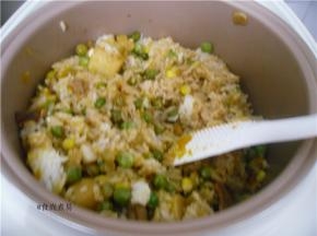 电饭锅煲饭程序结束，不要急着打开锅盖，焖10分钟左右，再用饭勺打散米饭，搅拌均匀即可