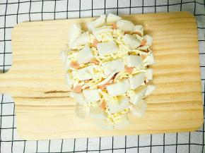 铺一层芝士，然后再塞火腿丁，最后撒一层芝士