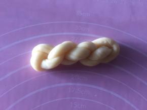 再对折绕三圈麻花，把尾巴塞入连着的一头