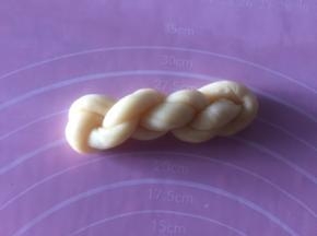 再对折绕三圈麻花，把尾巴塞入连着的一头