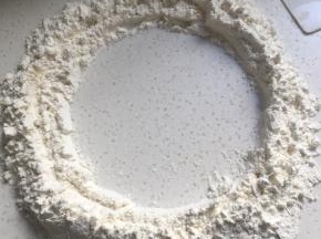 面粉放至桌面，中间划圈留出一个小圆
