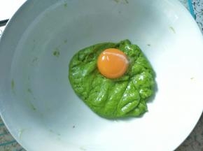 先把一个蛋黄加入菠菜面糊中，用硅胶刀轻翻拌均匀，混合，再加入下一个蛋黄，继续拌匀