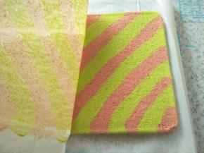 蛋糕放至不烫手，取一张比较长的油纸铺下面，把蛋糕倒扣在上班，迅速撕去上面的油纸，再把蛋糕翻过来