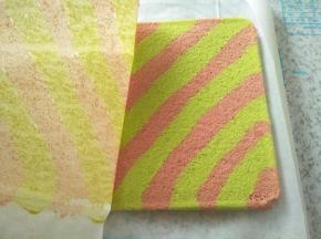 蛋糕放至不烫手，取一张比较长的油纸铺下面，把蛋糕倒扣在上班，迅速撕去上面的油纸，再把蛋糕翻过来