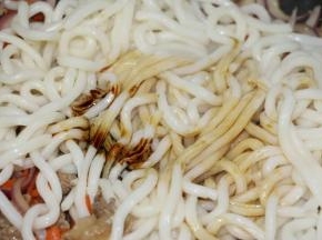 放入乌冬，倒入酱油、老抽