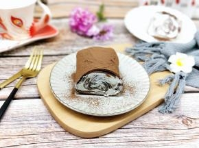 冷藏好后从冰箱取出，上面我们细筛筛上可可粉。再切开。我呢冷藏的时间不够，射出来的形状不太灵。