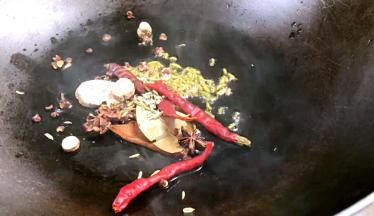 热锅热油，放入卤料、花椒、干辣椒炸香