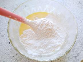 将蛋黄加入到酸奶中拌匀，再筛入低筋面粉和玉米淀粉。