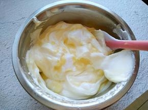 将蛋黄糊一次性倒入再打发好的蛋清中，翻拌均匀