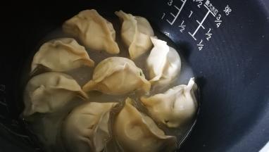 灯跳到保温键时开盖 加入清水至饺子一半处 盖好锅盖 按下煮饭键