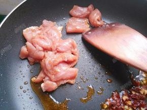 炒出红油后放入肉片翻炒变色