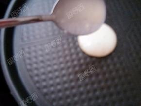 电饼铛预热，用勺子舀一勺面糊用慢慢滴入电饼铛内