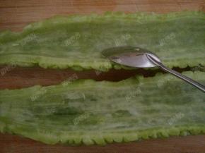 苦瓜对半切开，用勺子把里面白色的瓤去掉