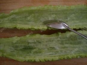 苦瓜对半切开，用勺子把里面白色的瓤去掉