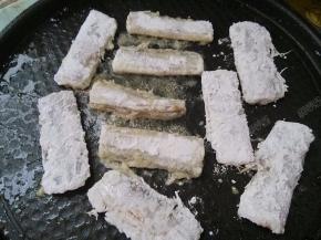 带鱼拍去多余的淀粉，然后放入电饼铛煎