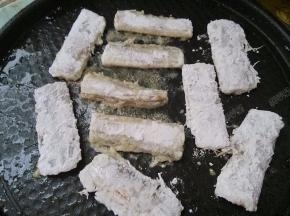 带鱼拍去多余的淀粉，然后放入电饼铛煎