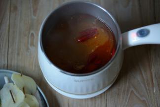 锅中加入适量的水，待水煮沸加入适量的火锅底料，姜片，浓汤宝继续煮沸。