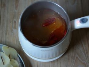 锅中加入适量的水，待水煮沸加入适量的火锅底料，姜片，浓汤宝继续煮沸。