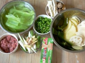 准备材料。土豆，藕去皮切薄片，青笋去皮刮薄片。牛肉切片加入淀粉和生抽腌制半小时。葱切段，姜切片，青椒切圈。