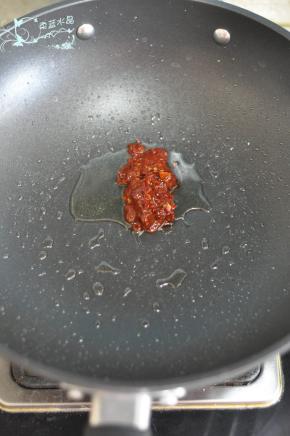 捞完肉后留底油，直接放入郫县豆瓣酱炒香。