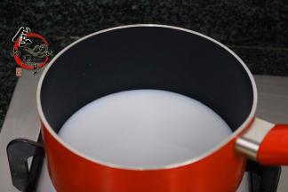 纯牛奶倒入奶锅中，大火煮开；