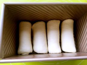 卷好的面团放入吐司模具内，盖上吐司盖入烤箱二次发酵，烤箱没有发酵功能的，可以放碗热水，中间温度降低，可以换碗新的热水