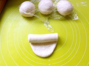 之后将擀好的面团翻个面，将光滑的一面朝下放，之后卷起来