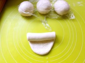 之后将擀好的面团翻个面，将光滑的一面朝下放，之后卷起来