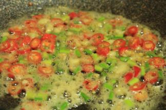 下辣椒、蒜苔，下蚝油提鲜，就不用放鸡精了，再加一勺生抽，少许盐，生抽和蚝油都有盐分哦，翻拌均匀