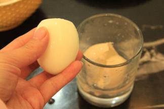 用一个杯子，放入煮好的蛋，加入清水，用手掌盖住杯口开始摇晃，让鸡蛋撞击杯壁，差不多看到蛋壳基本都碎了，破了，鸡蛋很方便的就可以了从壳里滑溜出来，完整又快捷