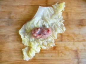 把处理好的白菜铺平，放入一汤勺肉馅整理成圆柱形