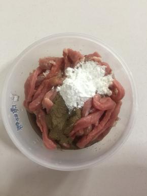 切好的里脊肉中加入两勺料酒，两勺生抽，两勺玉米淀粉，一勺胡椒粉。