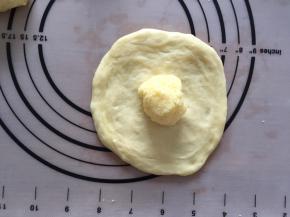 将面团压扁压圆，放上一份椰蓉馅，包起来