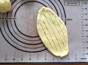 用擀面棒擀成椭圆形，用锋利的刀划出几条口，划破，两头不要切断