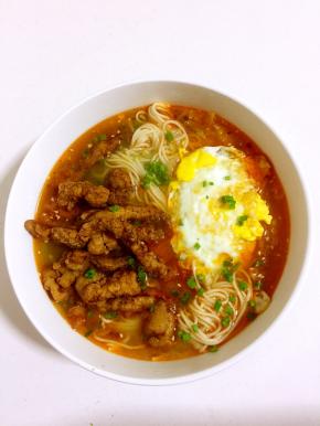 放入炸好的里脊肉，煎好的荷包蛋，撒上适量的葱花即可享用美味啦！