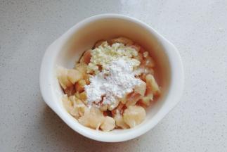 再把鸡肉丁放入碗中，加入少许盐，料酒，生抽，淀粉和蒜末拌均匀腌制20分钟；