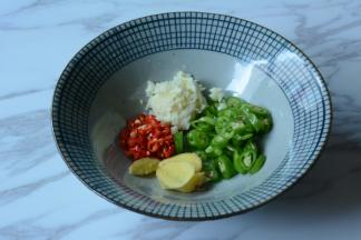 青椒，小米辣切细碎。蒜压泥，姜切薄片。