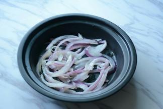 洋葱过滚水烫一下捞出放入盘中。